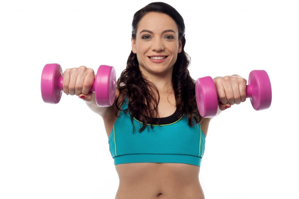 Young fitness woman lifting dumbbells